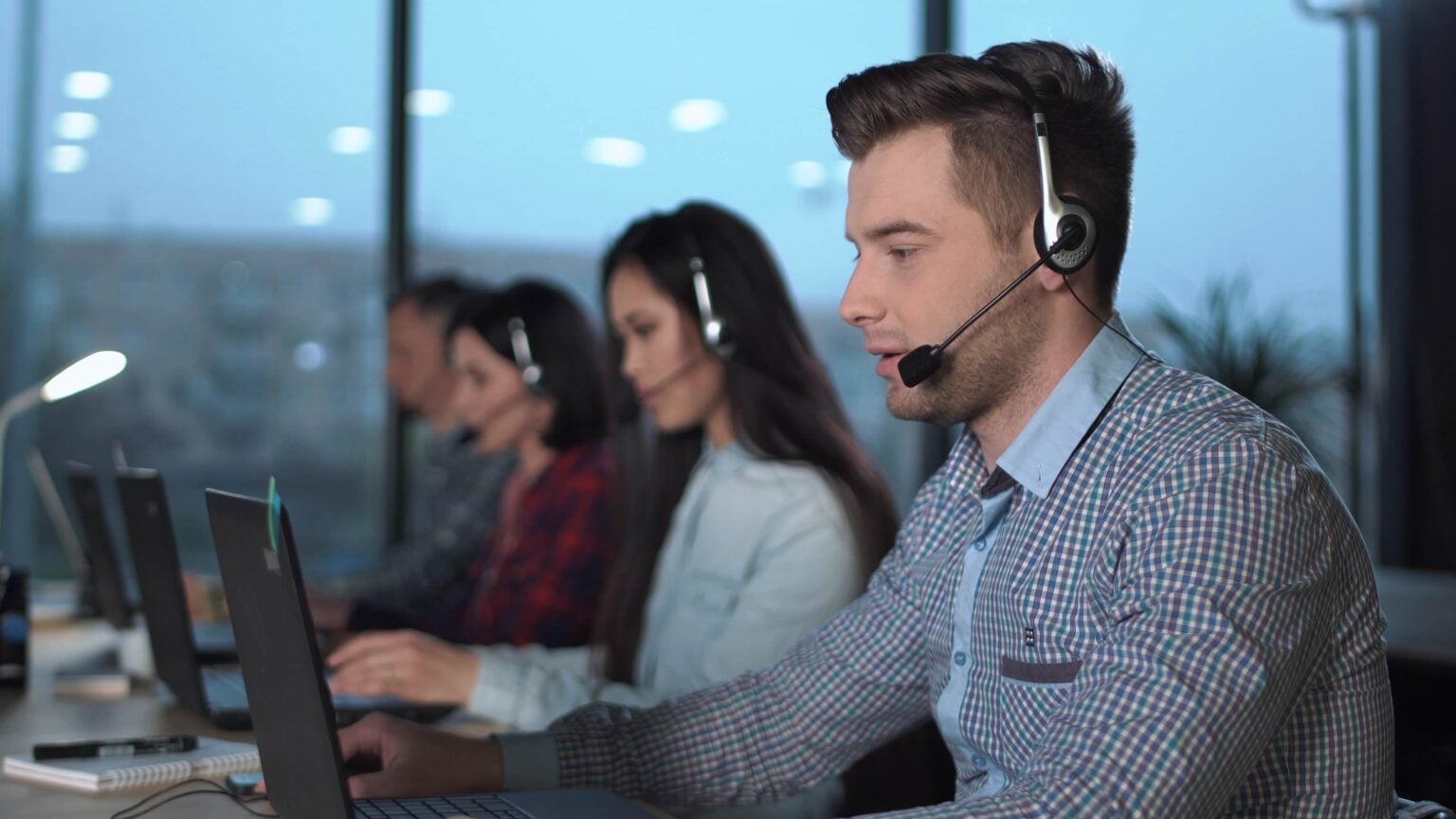 Service desk engineers on headsets at their desks
