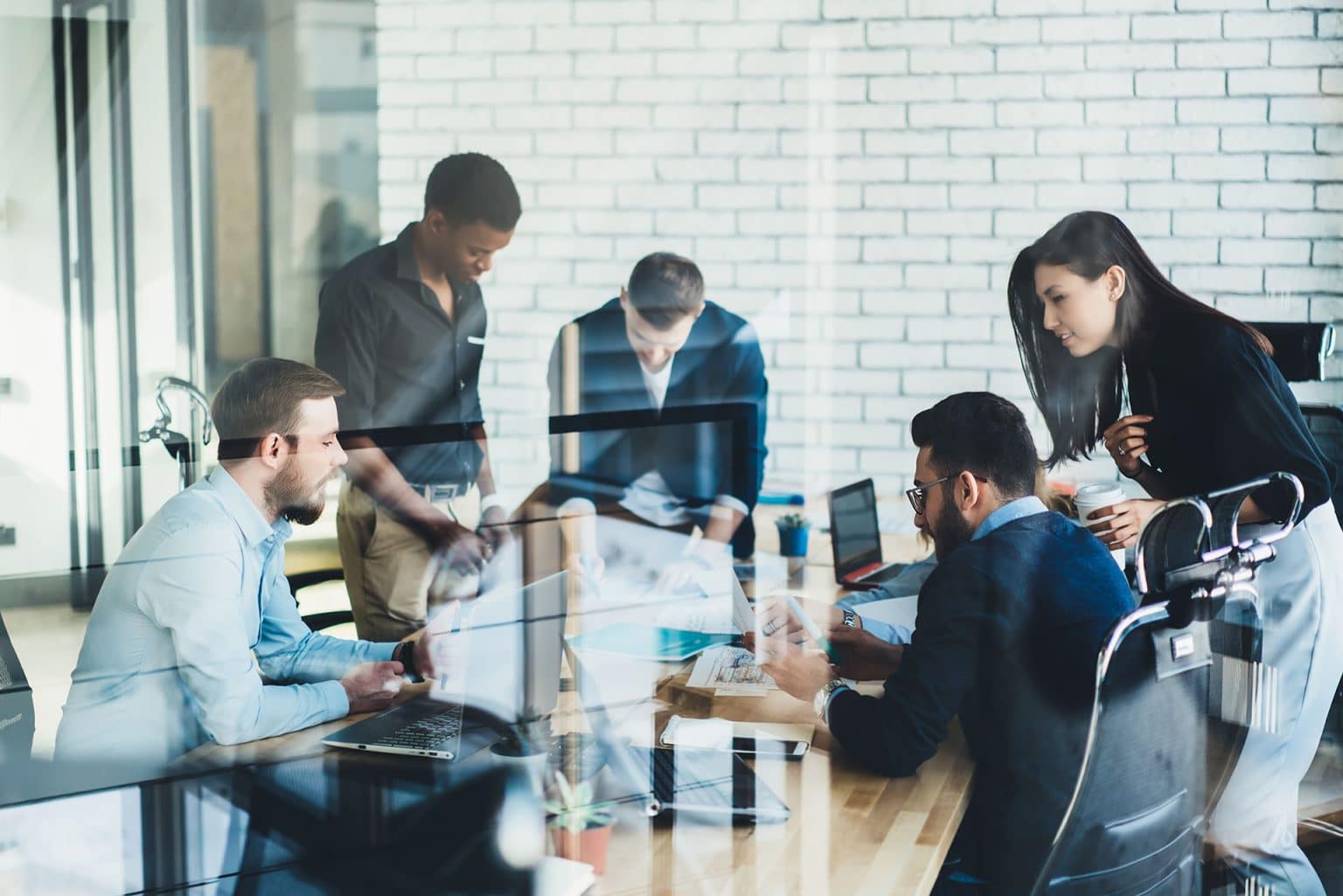 A team working together around laptops in an office