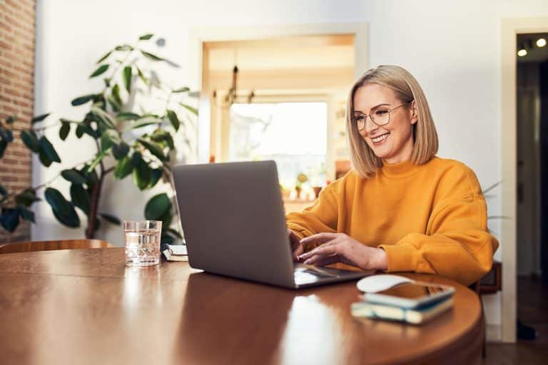 A woman working on her laptop at a cafe table