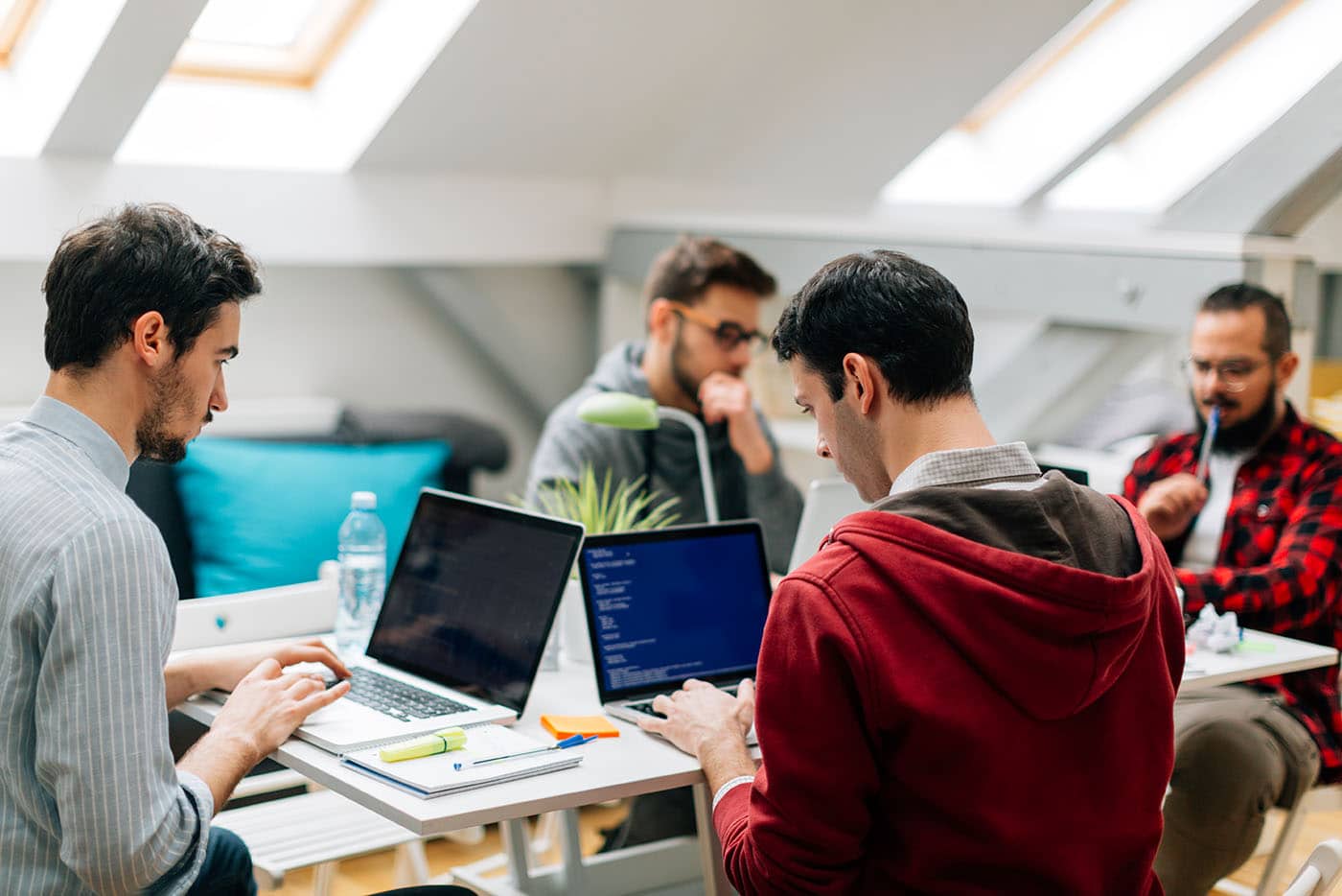 A small team working through a plan at their laptops