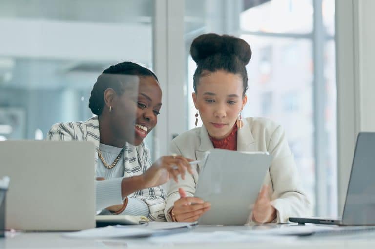 Two colleagues going through a security report on a tablet