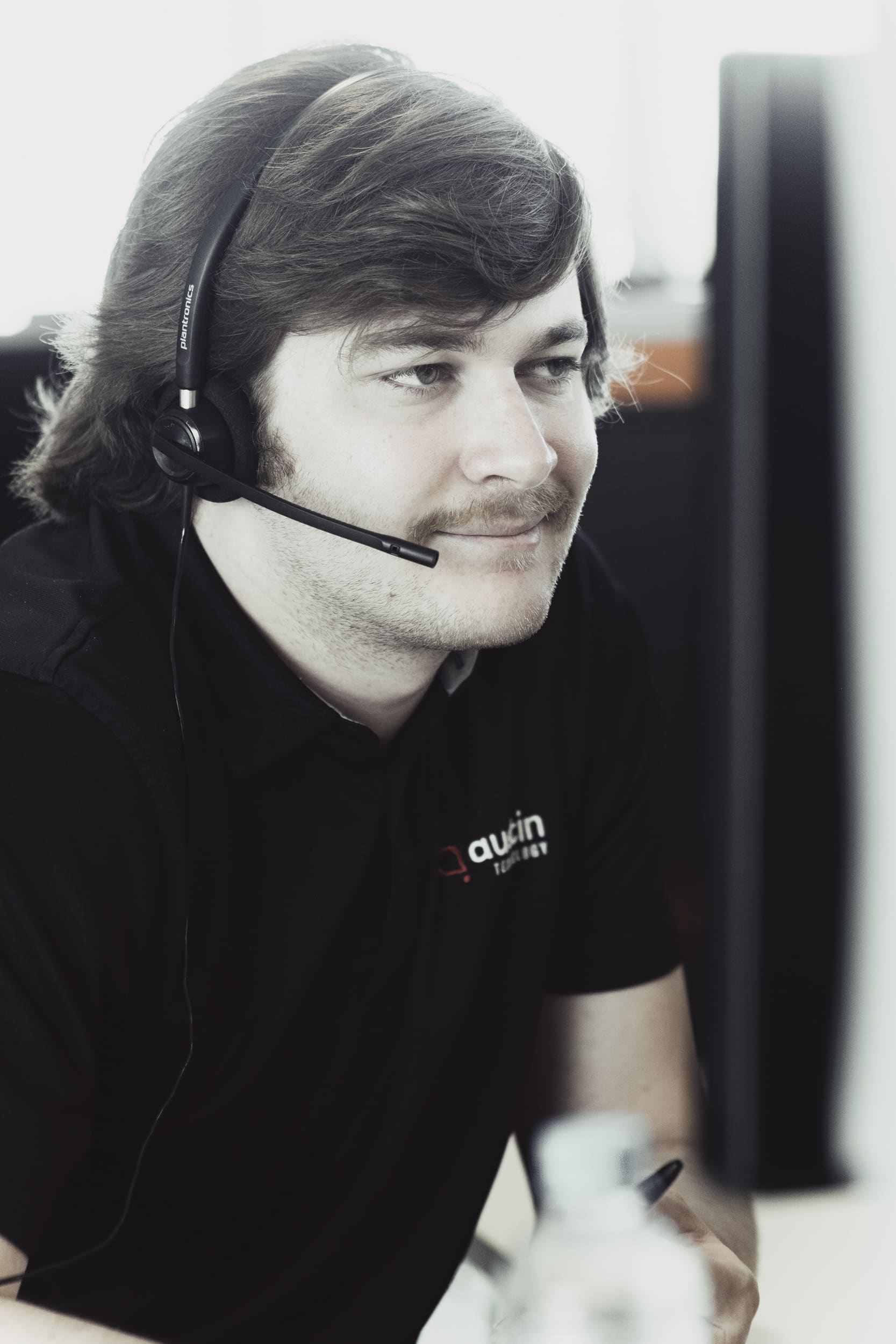 Austin Technology service desk engineer on a headset, working through a client request