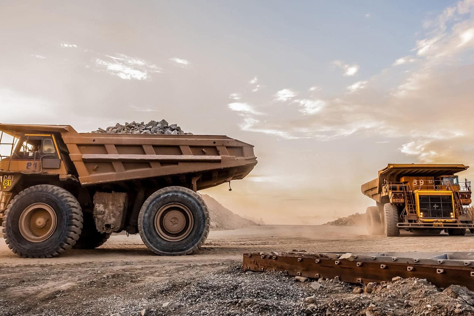 Haul trucks on a mine site at sunrise