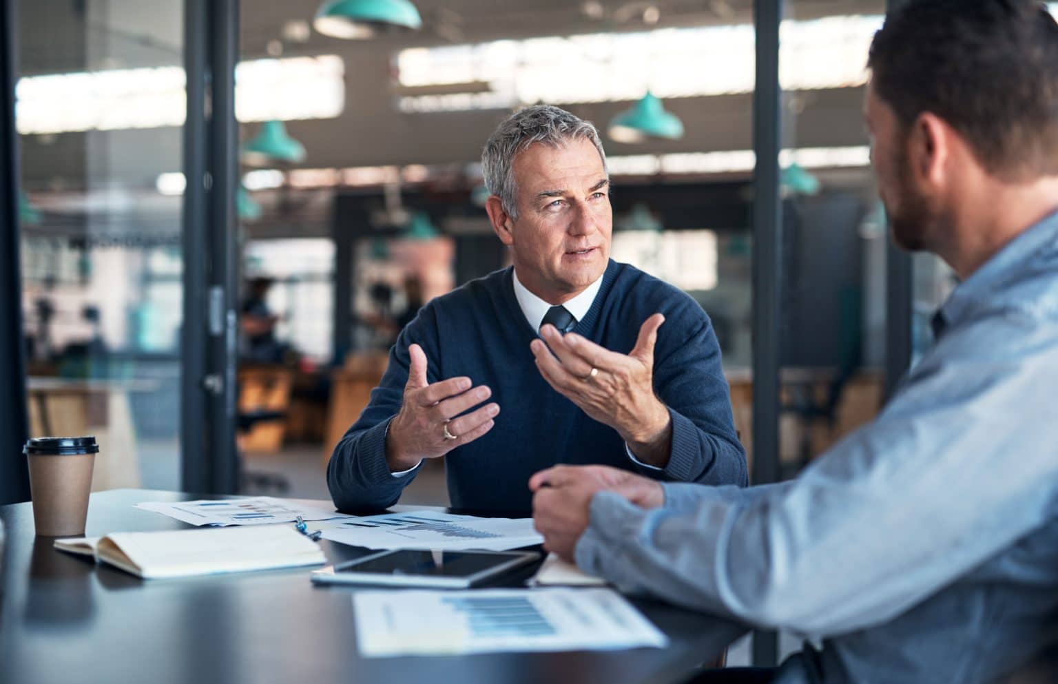 Two consultants talking through a proposal at a desk