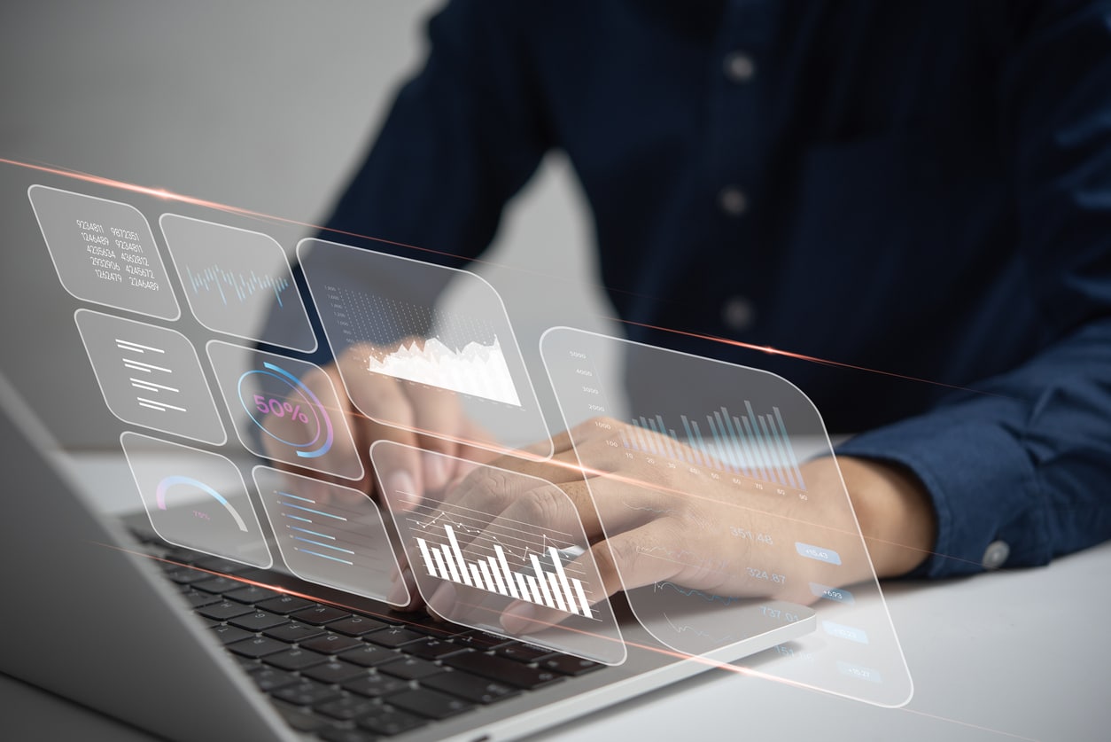 Hands on a laptop with charts overlaid
