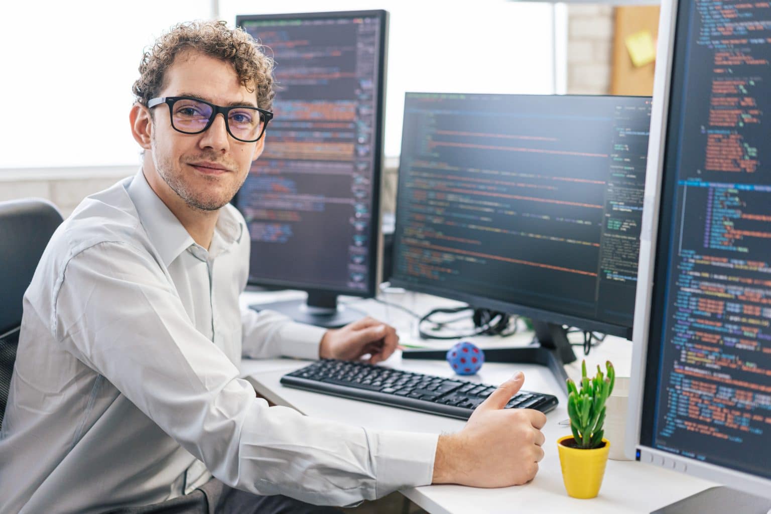A developer at a desk with code on several screens