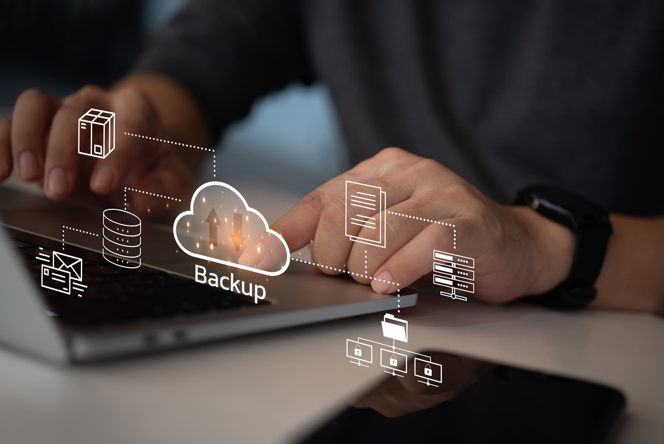 Hands on a laptop with backup and cloud icons overlaid