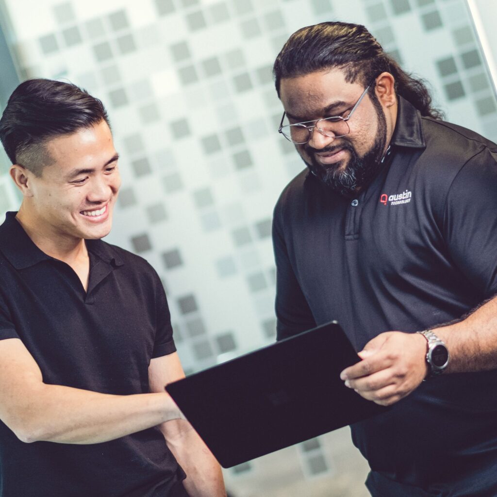 Two Austin Technology engineers reviewing a hybrid cloud design on a laptop