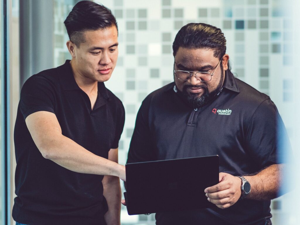 Two Austin Technology engineers working through a project on a laptop