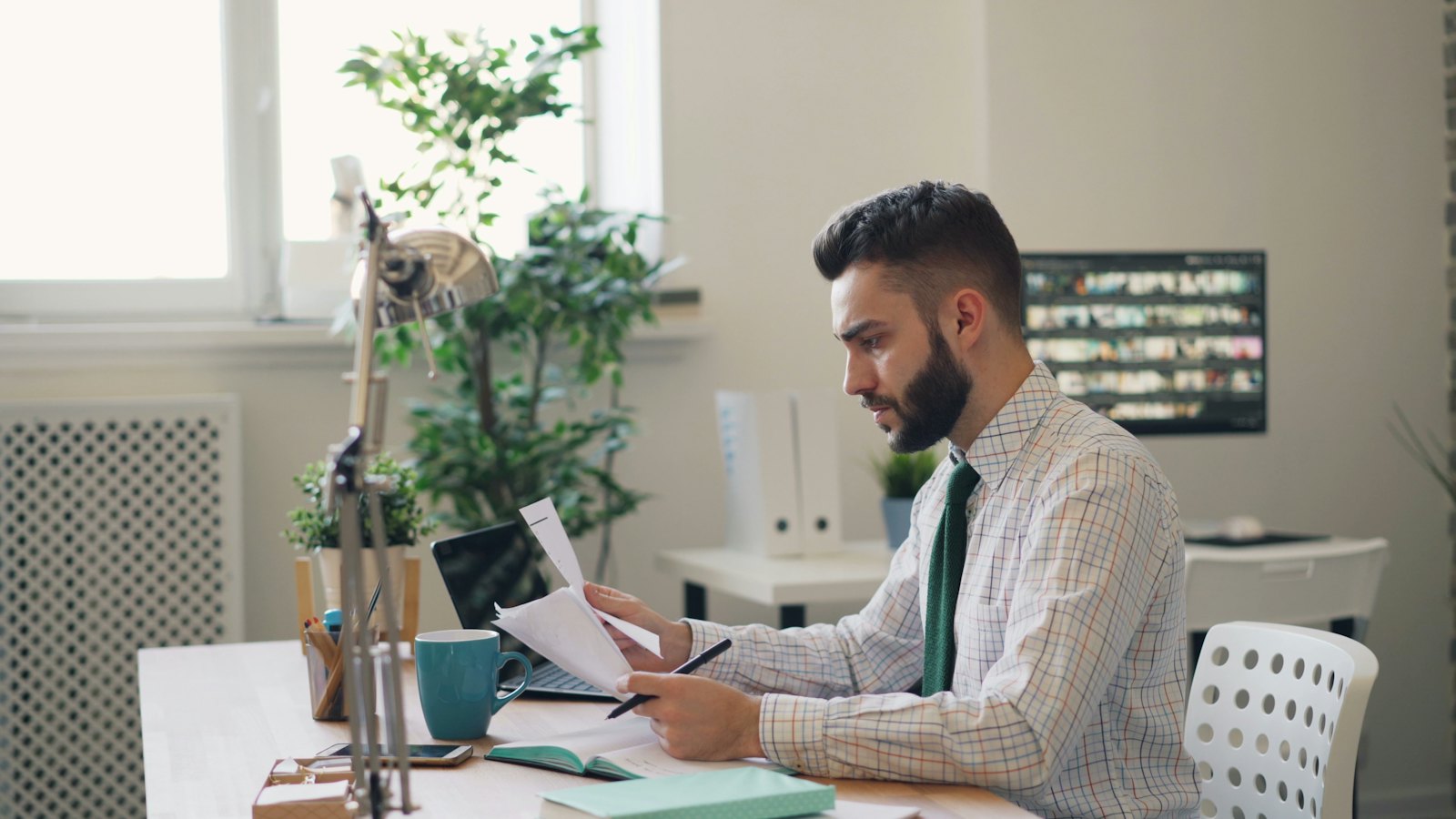 Man reviewing printed documents at his desk