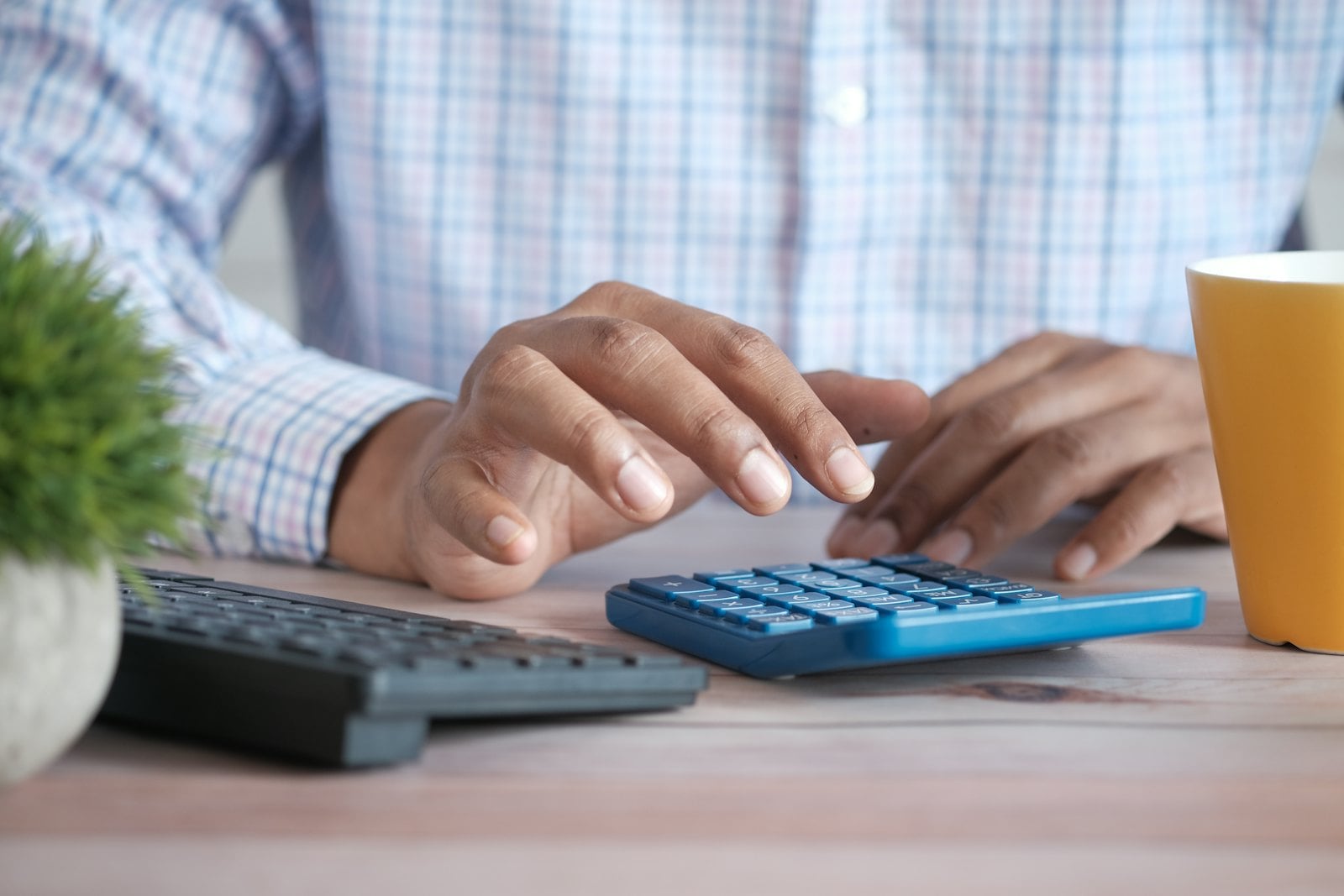 Person working through figures on a calculator at a desk