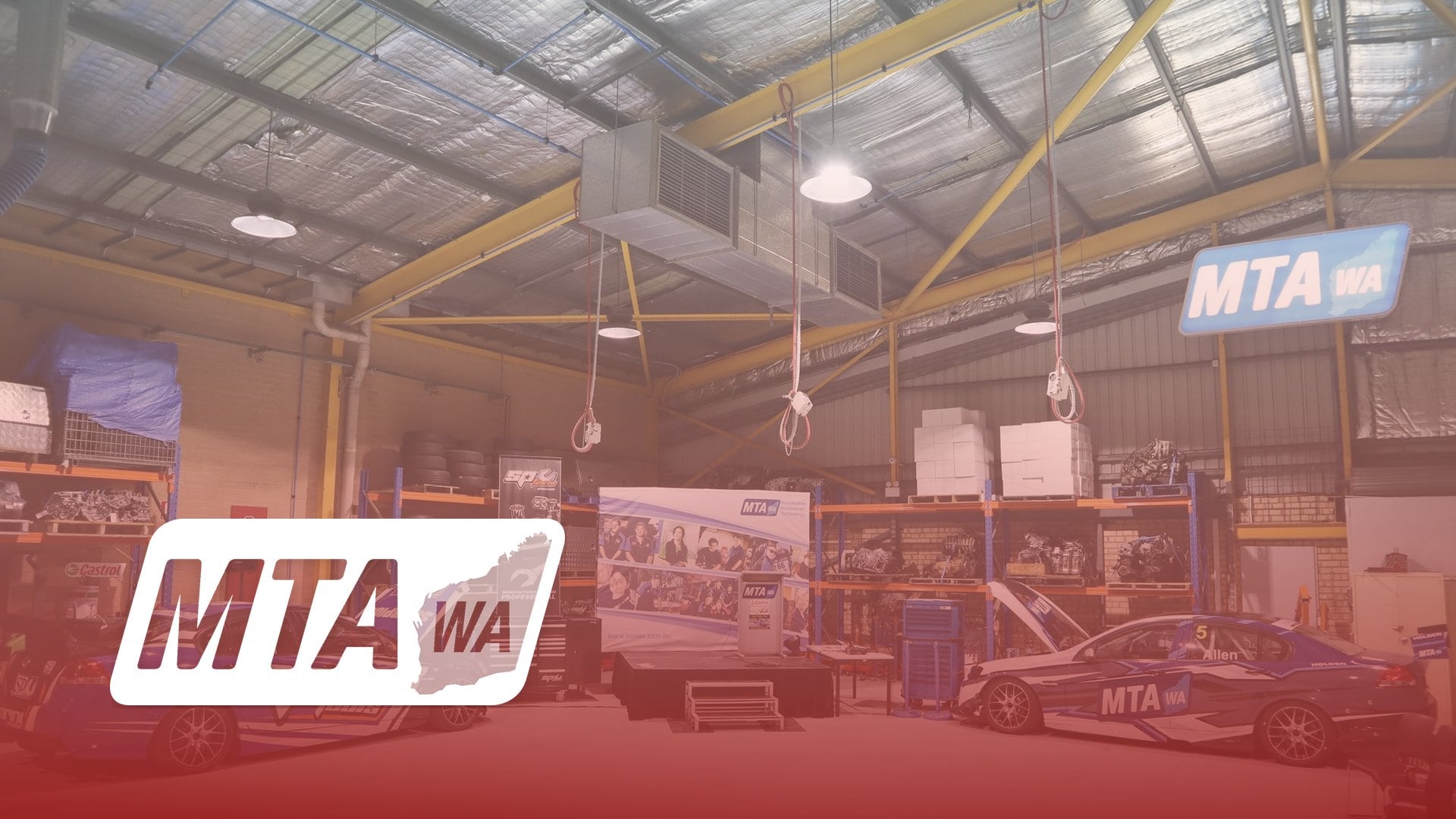 MTA WA logo over race cars and equipment inside the MTA WA training workshop