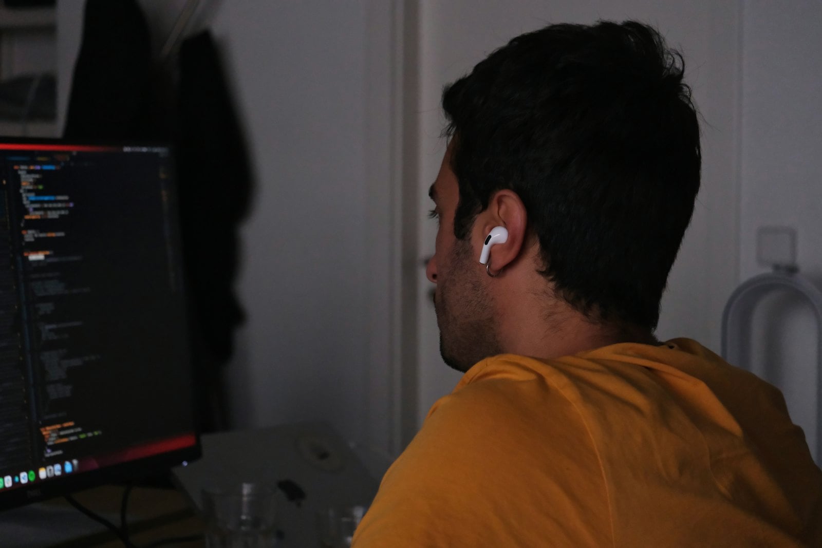 Man at a computer screen in a dim office