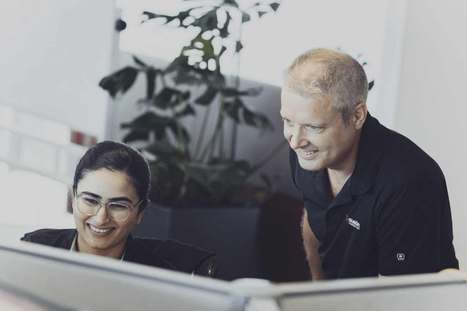 An Austin Technology engineer helping a colleague at her desk