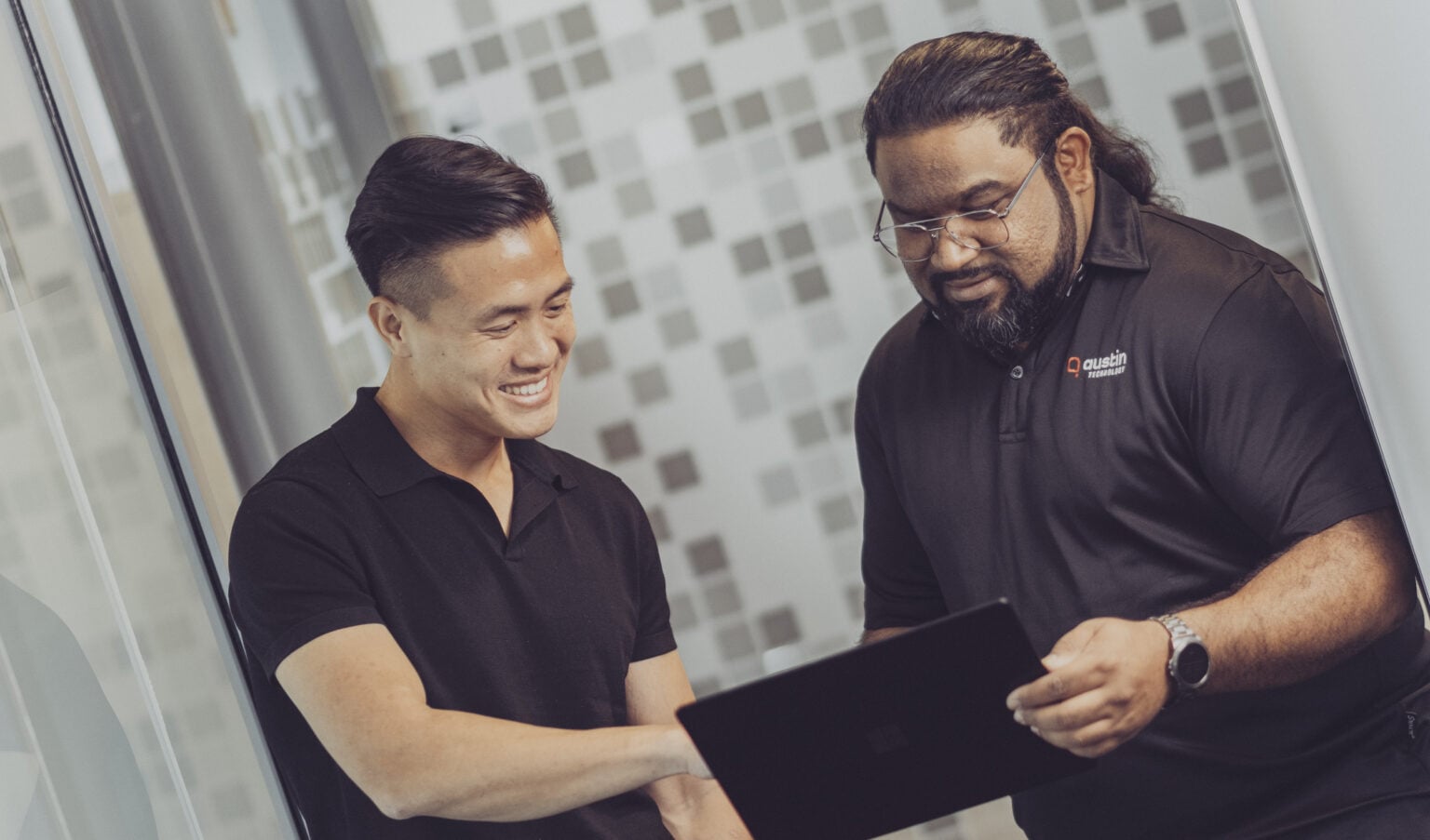 Two Austin Technology engineers looking at a tablet in the office