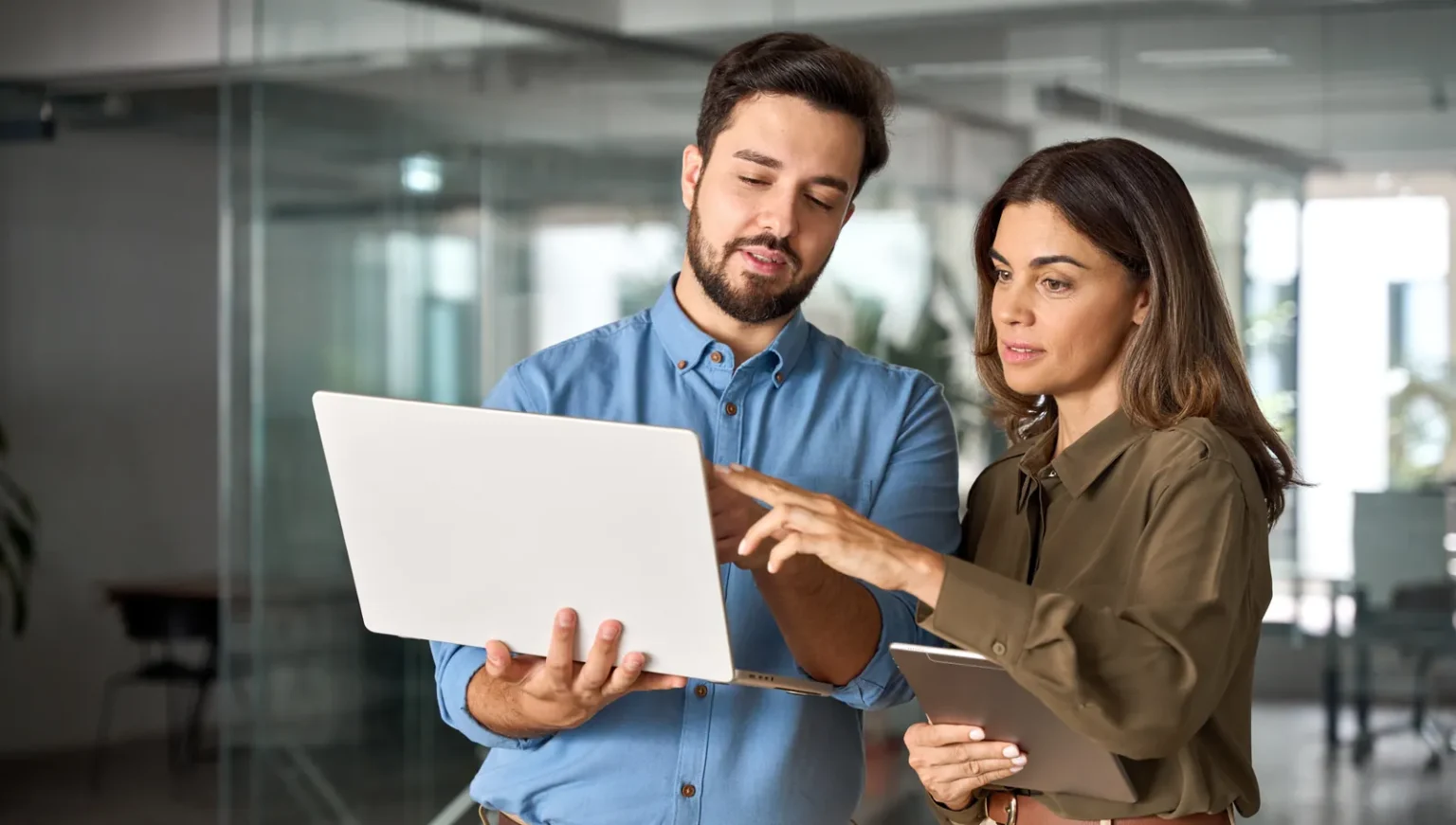Two colleagues reviewing AI tool usage on a laptop