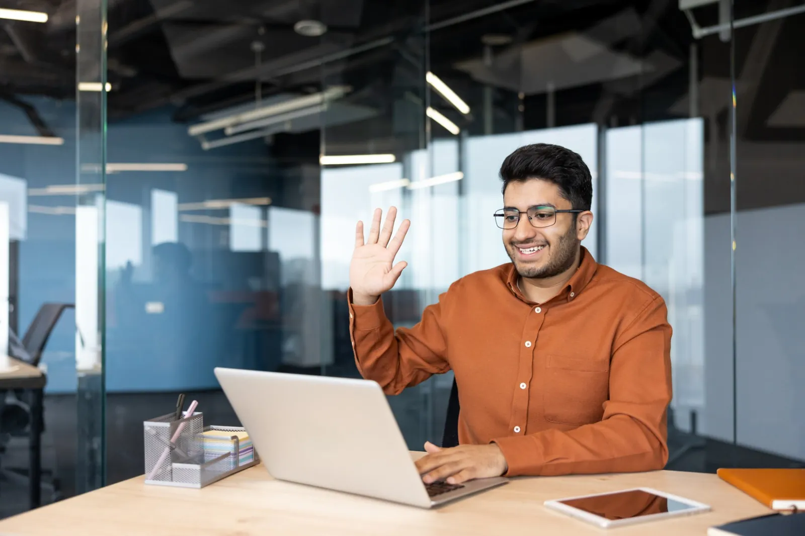 Someone on a Teams video call at their laptop in a bright office